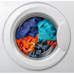 Washing machine cleaning colourful assortment of printed clothes.