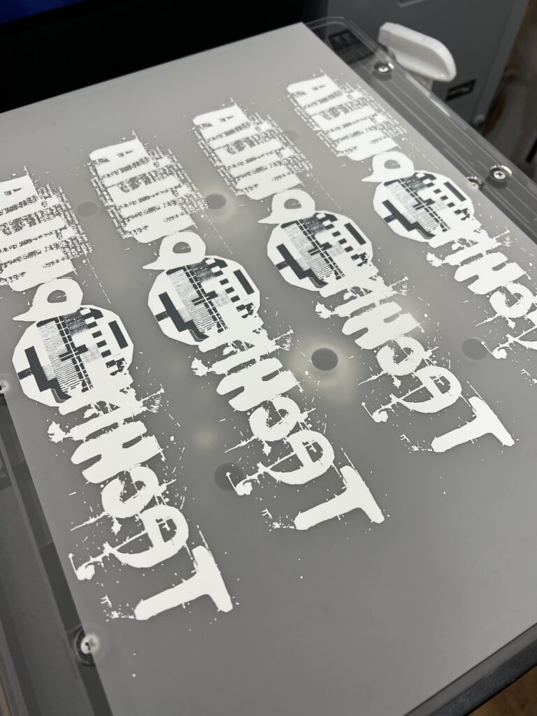 DTF printing process with graphics being printed onto a grey background.