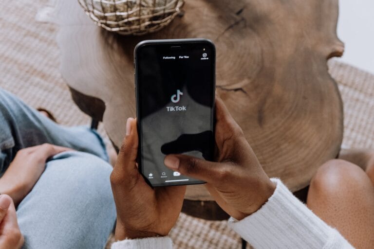Fashion enthusiast holding a smartphone whilst logging in to TikTok.