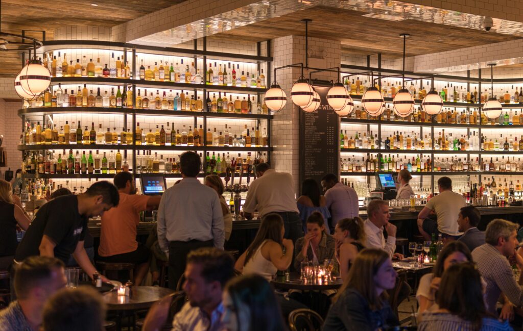 A restaurant environment, featuring a busy bar. 