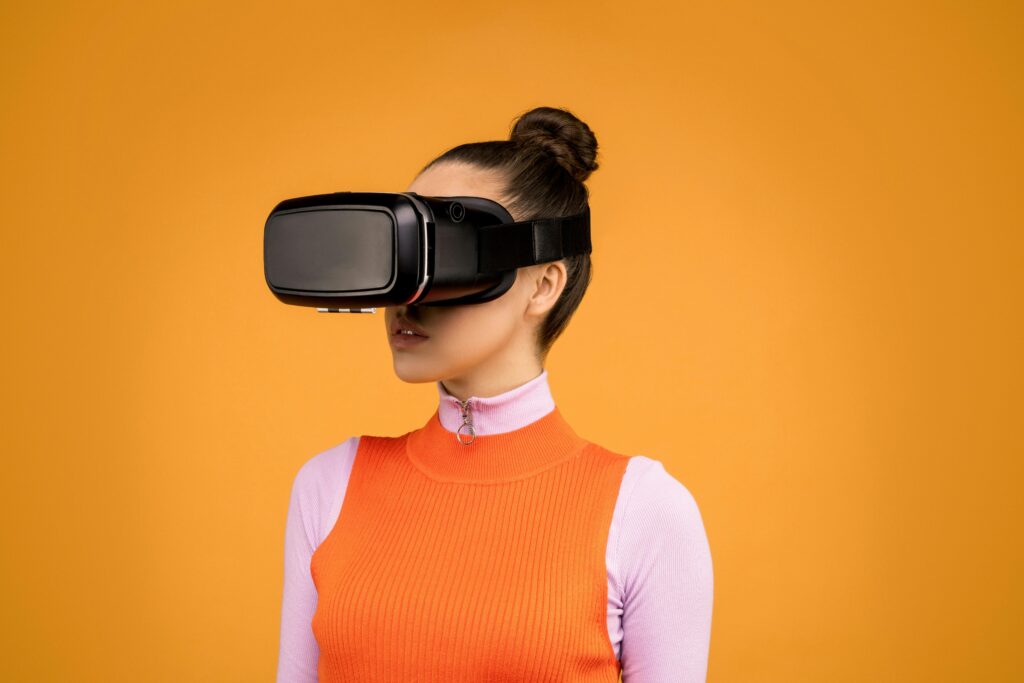 Lady wearing a trendy orange outfit, wearing a VR headset to try on different clothing garments.